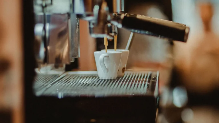 Automatic coffee machine dispensing espresso into two small cups