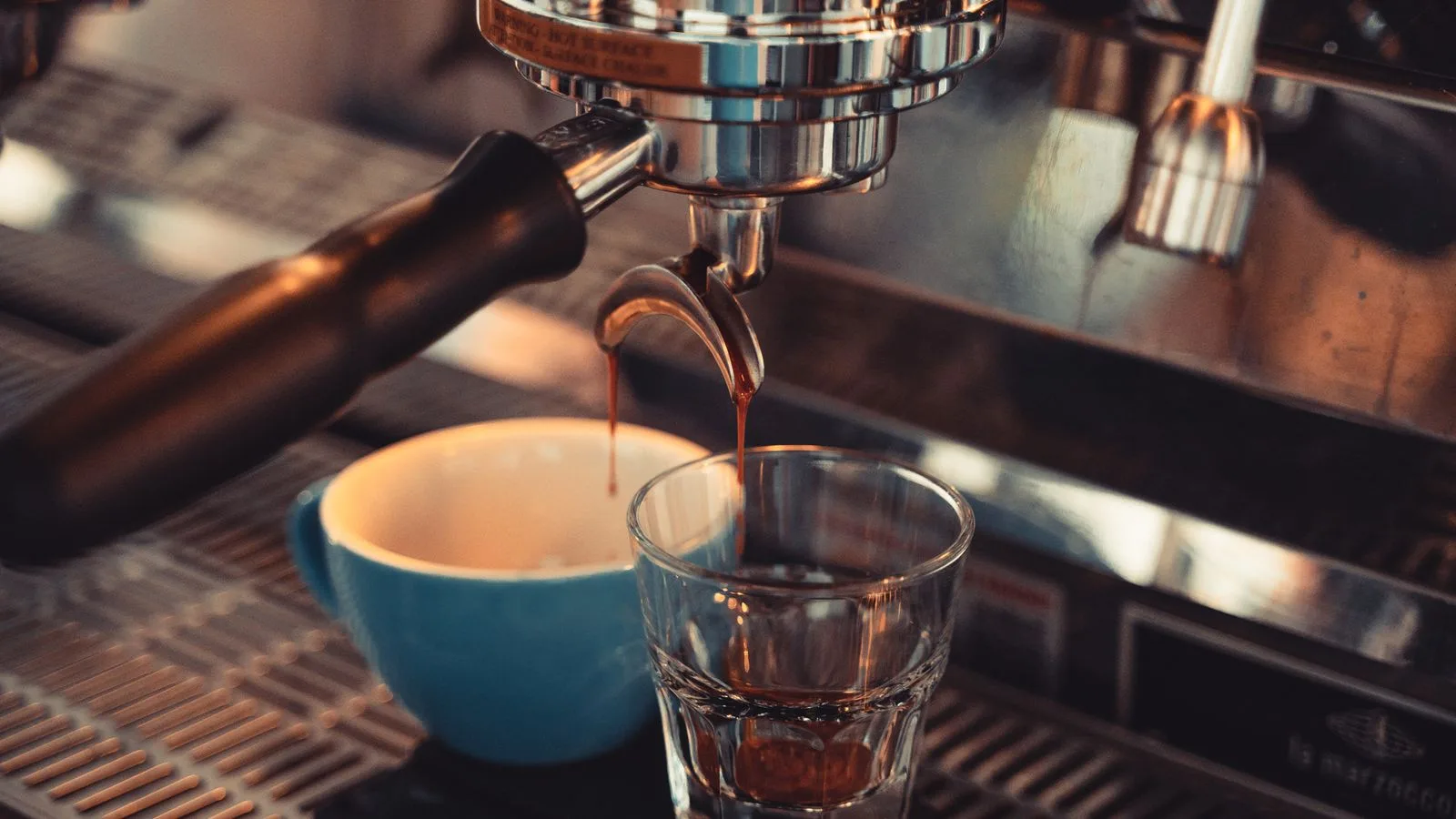 Espresso running from a machine group head into a glass
