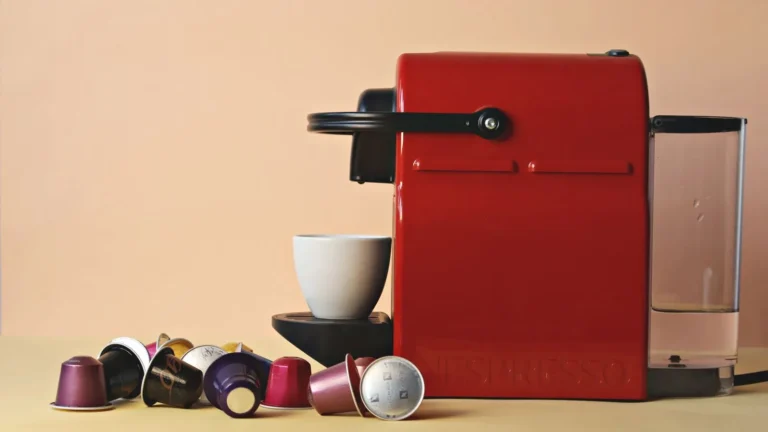 Red pod coffee machine surrounded by loose coffee capsules